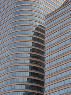 2 skyscrapers filling the frame, one reflecting off the other's windows