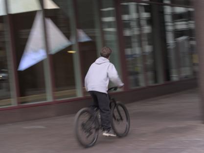 Kid biking in downtown area with motion blur